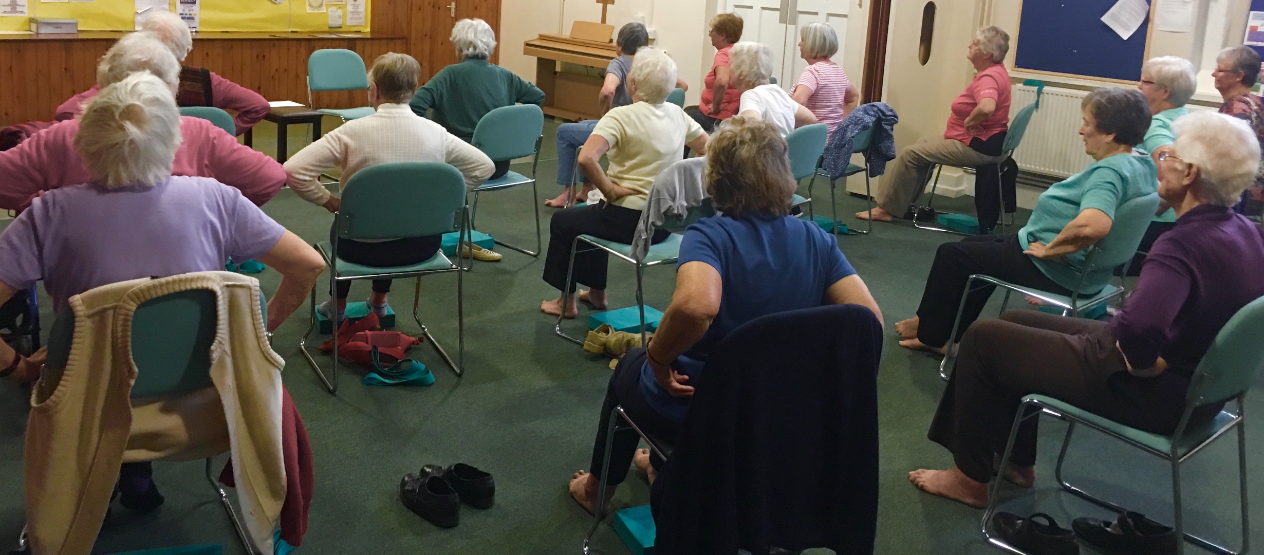 Senior Citizens participating in an exercise class seated in chairs