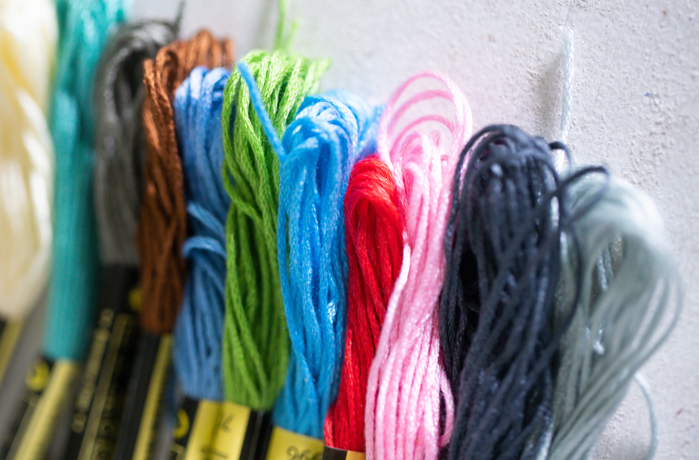 A photograph of different coloured threads all placed together