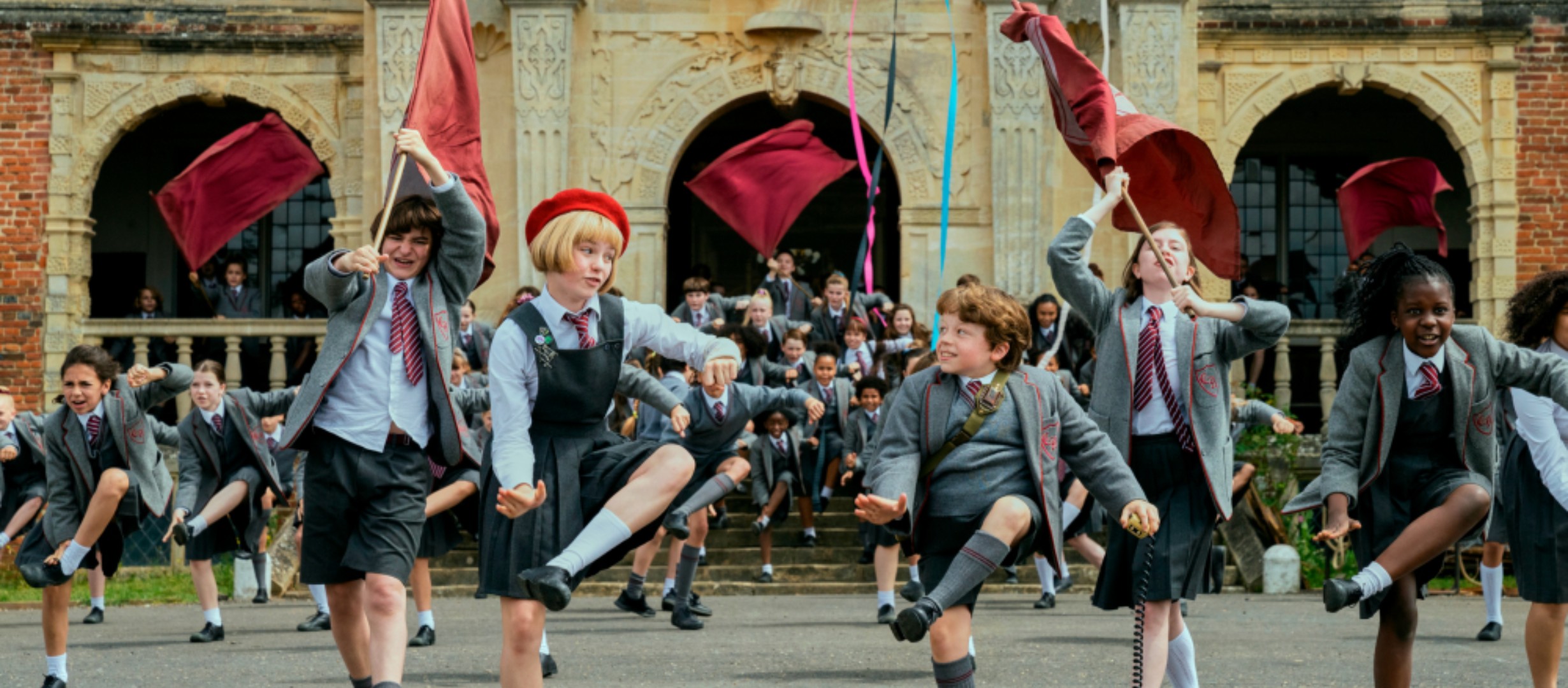 group of children in school uniform happily dancing
