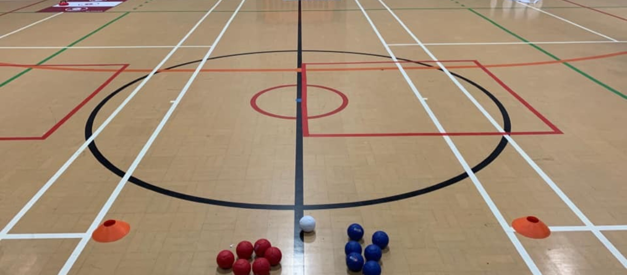 photo of sports hall floor with boccia balls and cones