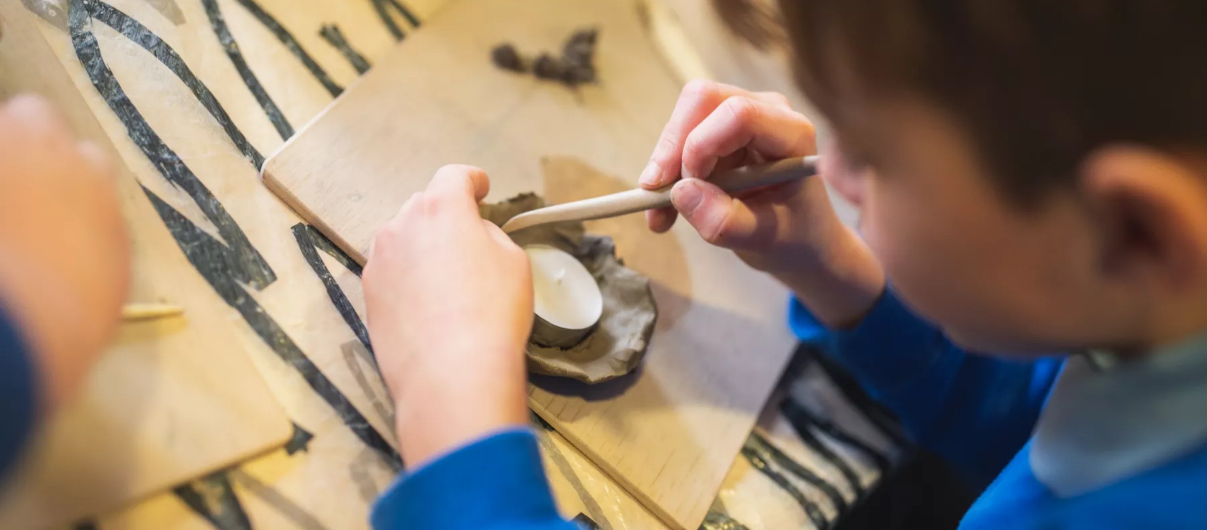 Child making a clay candle holder