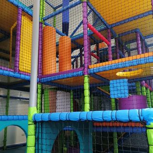 A very bright, clean and colourful extensive three tier soft play with an overhead hoist. There are steps, slides, obstacles and hiding places.
