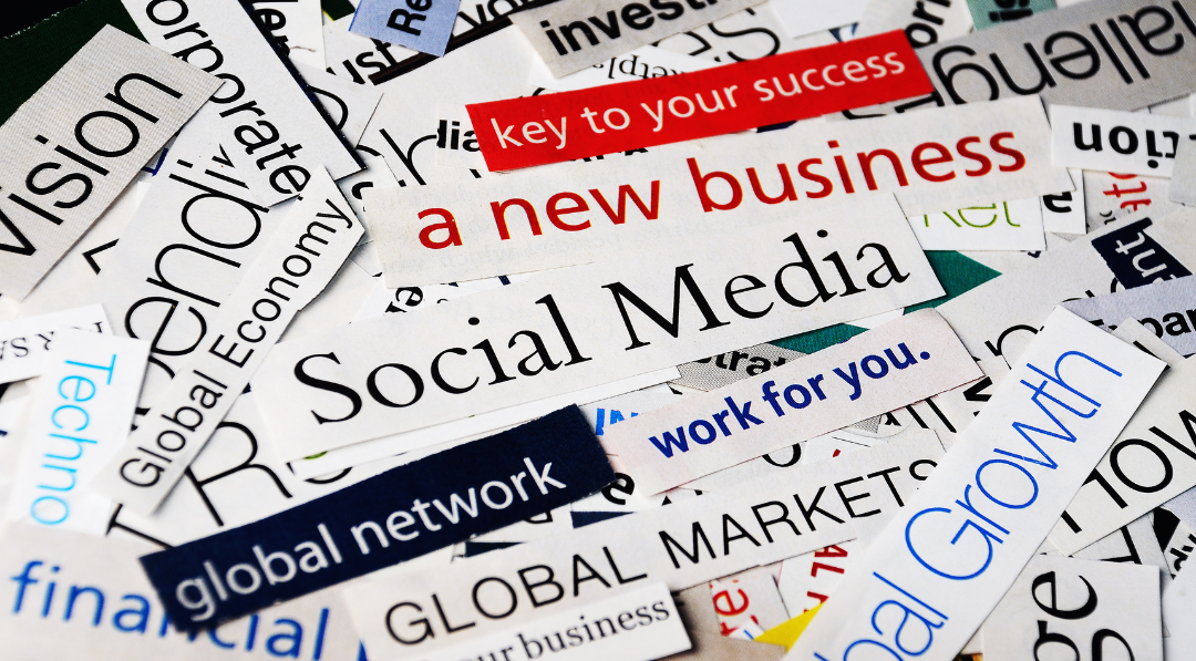 A photograph of bits of paper with words which relate to social media, business success and helping to promote your business