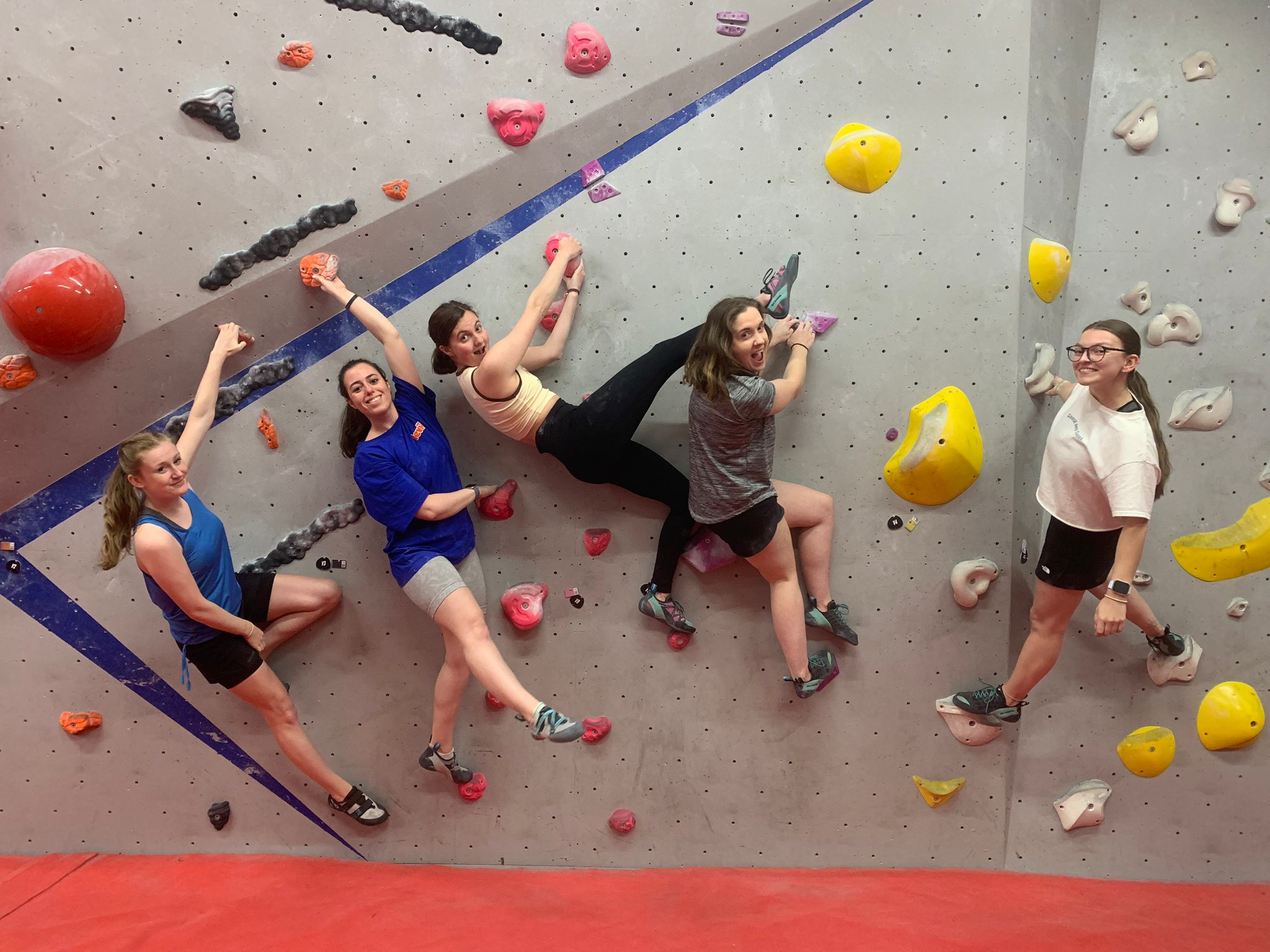 Climbers on a climbing wall having fun and smiling for the camera.