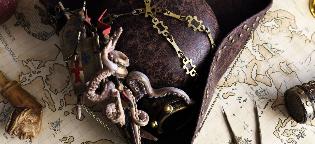This exciting photograph has a pirate hat made from leather in the centre. It is placed on a map, and on top of the hat you can see octopus tendrils