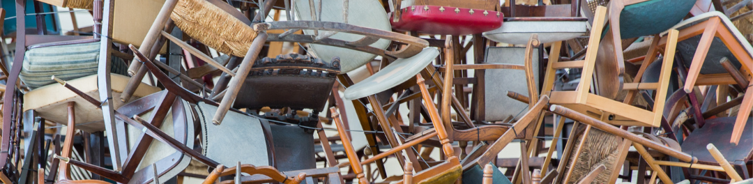 This is a photograph of different styles of chairs all stacked up together