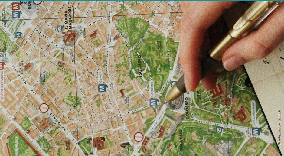 A photograph of a map with a persons hand adding details in pen