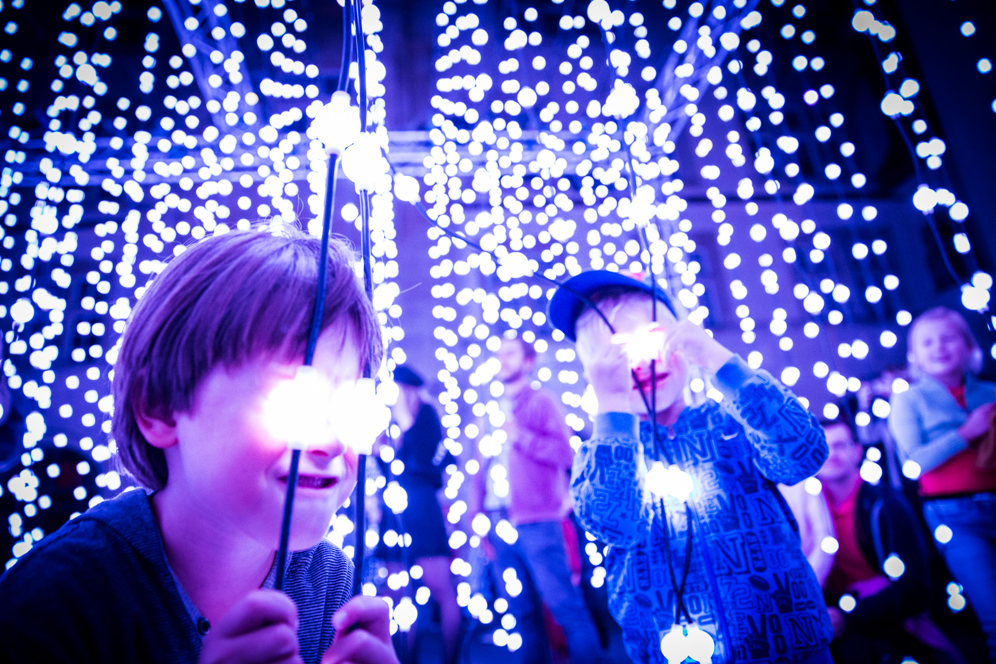 Children having fun with glowing lights in a cozy room.