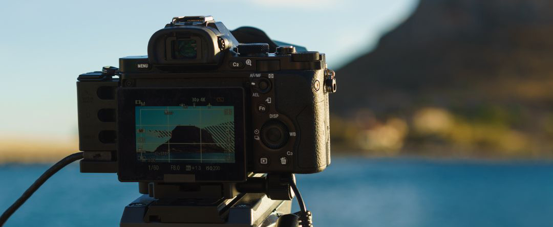 This is a photograph of a digital camera set up ready to capture a beautiful sea scene