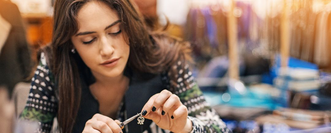 A young woman is creating some jewellery using crafting tools