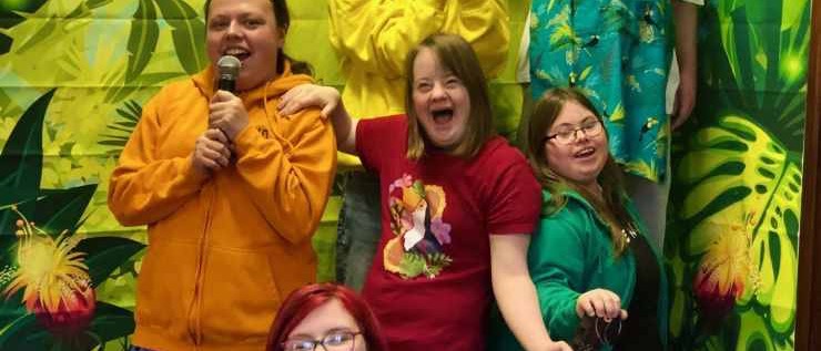 A group of young people being creative smiling and holding Toucan birds.