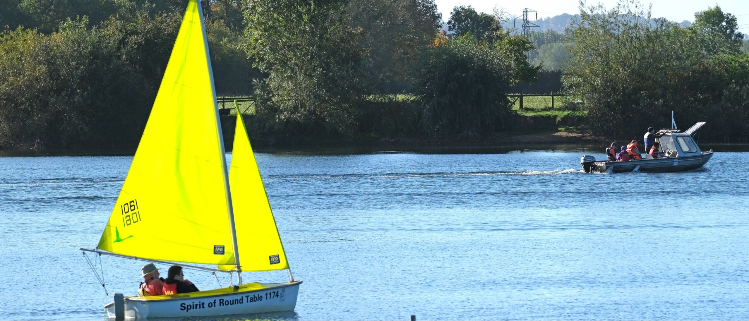 Photo of people enjoying a trip in an accessible sailing dinghy and powerboat on the lake at Frampton on Severn Sailing Club