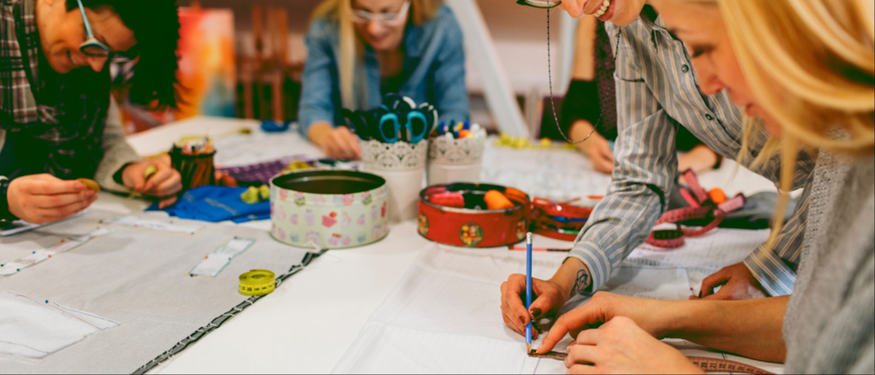 This is a photograph of a small group of people working on some textile projects together.