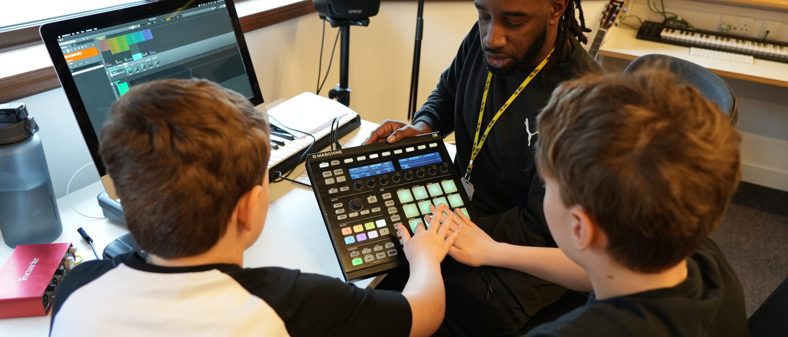Mix and Mash weekends. Two young people working with music leader on making beats.